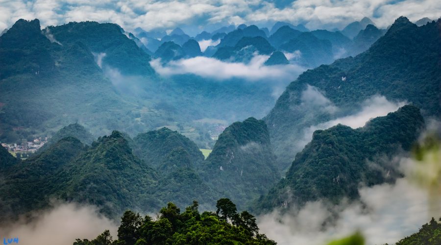 俯瞰视角的仙侠宗门建筑群鸟瞰图，青瓦飞檐层层叠叠沿山势铺开，云雾缠绕山腰，整体色调偏焦橙与深棕，气势恢宏