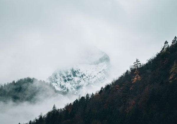 水墨风格的仙侠山川长卷，云海翻涌间隐约可见古殿飞檐，画面主色为焦橙与深棕，气氛苍茫悠远